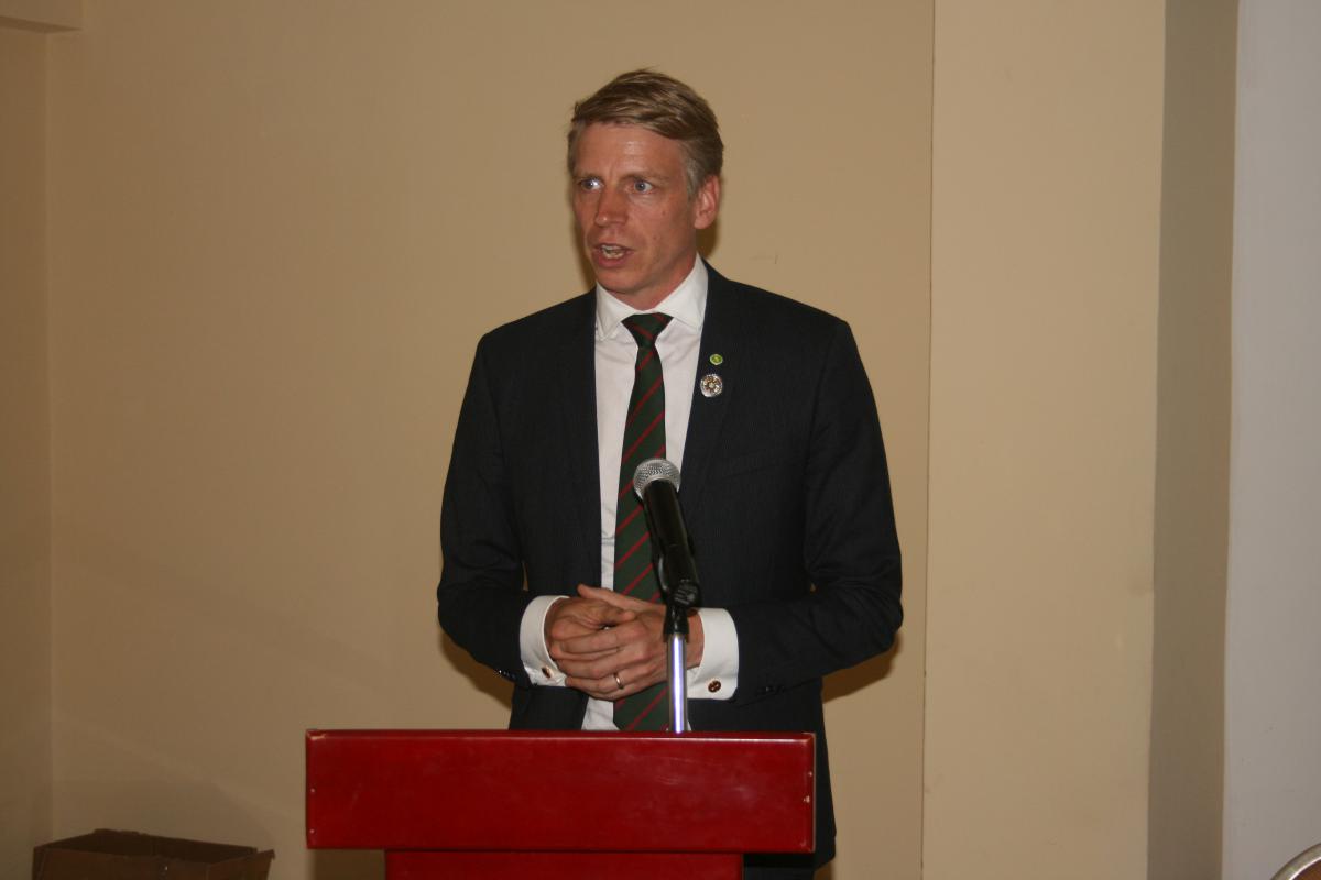 Minister Bolund speaking at a podium 