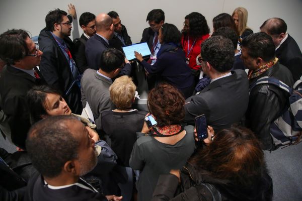 Delegates huddle in a hallways at COP 25 in Madrid in 2019; summits like these have been canceled or postponed since COVID-19