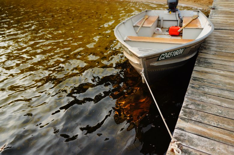 Boat tied to a dock in a lake in northern Ontario, Canada.