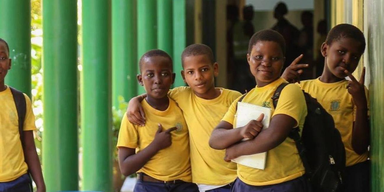 Group of children in a school hallway posing for the camera. 