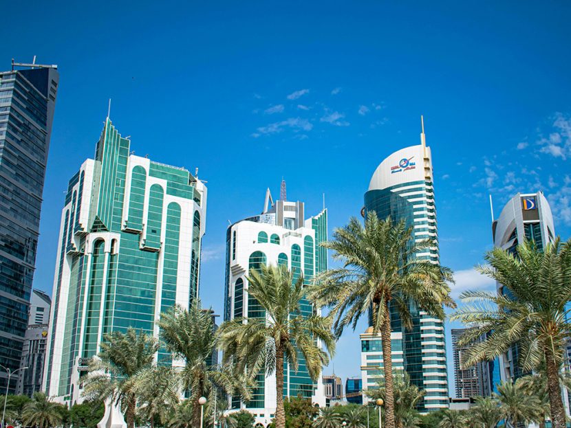Palm trees surround high-rise buildings in Qatar.