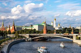 The Kremlin in Moscow is seen behind boats on a river.