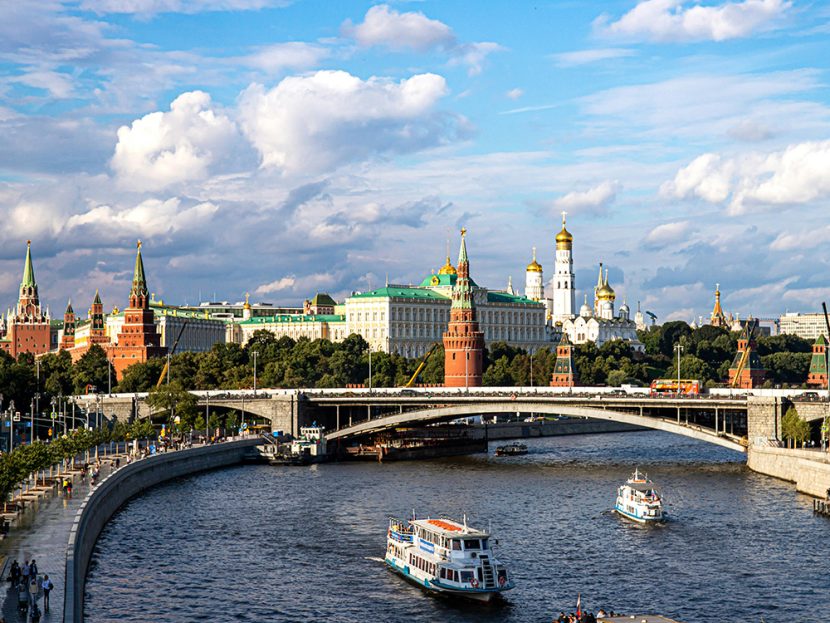 The Kremlin in Moscow is seen behind boats on a river.
