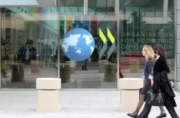 Two women walk past an OECD office.