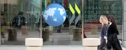 Two women walk past an OECD office.