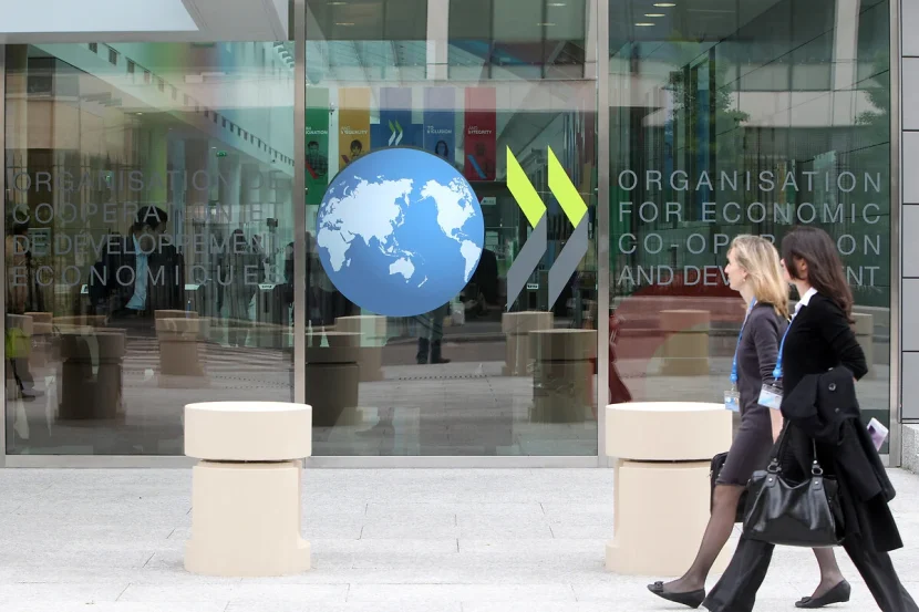 Two women walk past an OECD office.