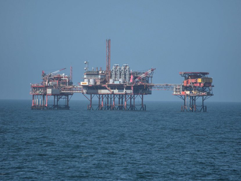 An oil rig platform stands above the sea.