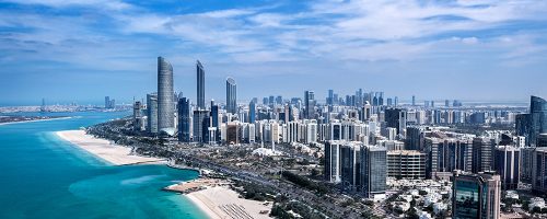 Tall city buildings along a beach.