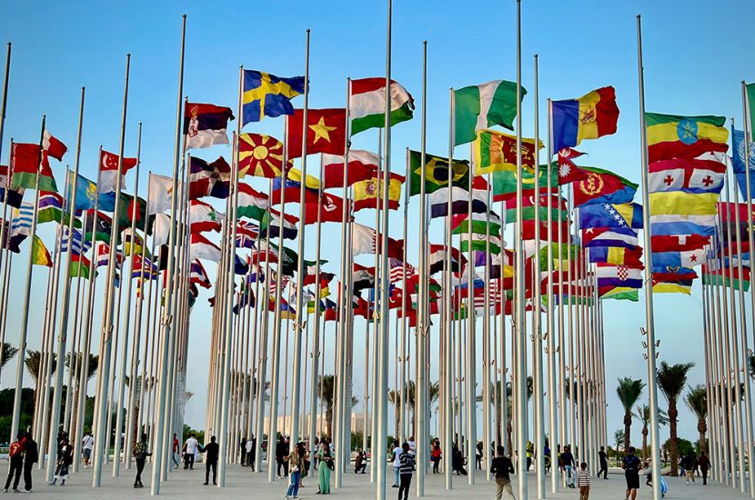 Spectators stand under dozens of country flags.
