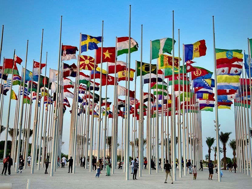Spectators stand under dozens of country flags.