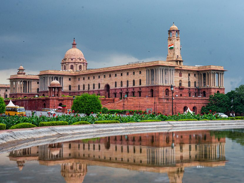 A building is reflected in a pool of water.