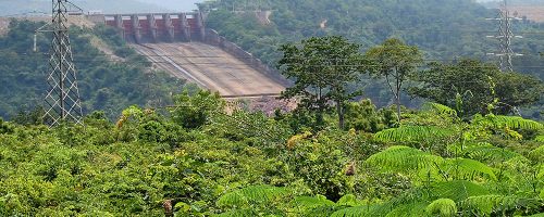A hydro-electricity dam surrounded by lush vegetation.
