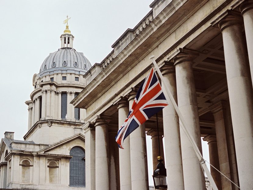 A red-white-and-blue flag flies in front of a building.