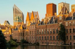 The setting sun glows upon buildings in a city.