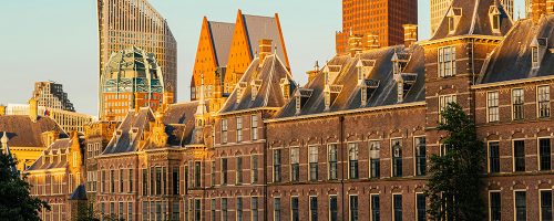 The setting sun glows upon buildings in a city.