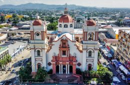 A brown-and-white cathedral in a city.