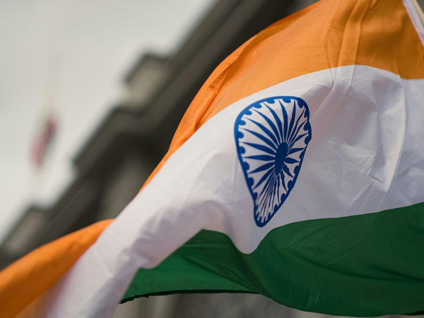 An orange-white-and-green flag with a blue emblem.
