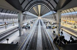 Travellers are seen in a train station.