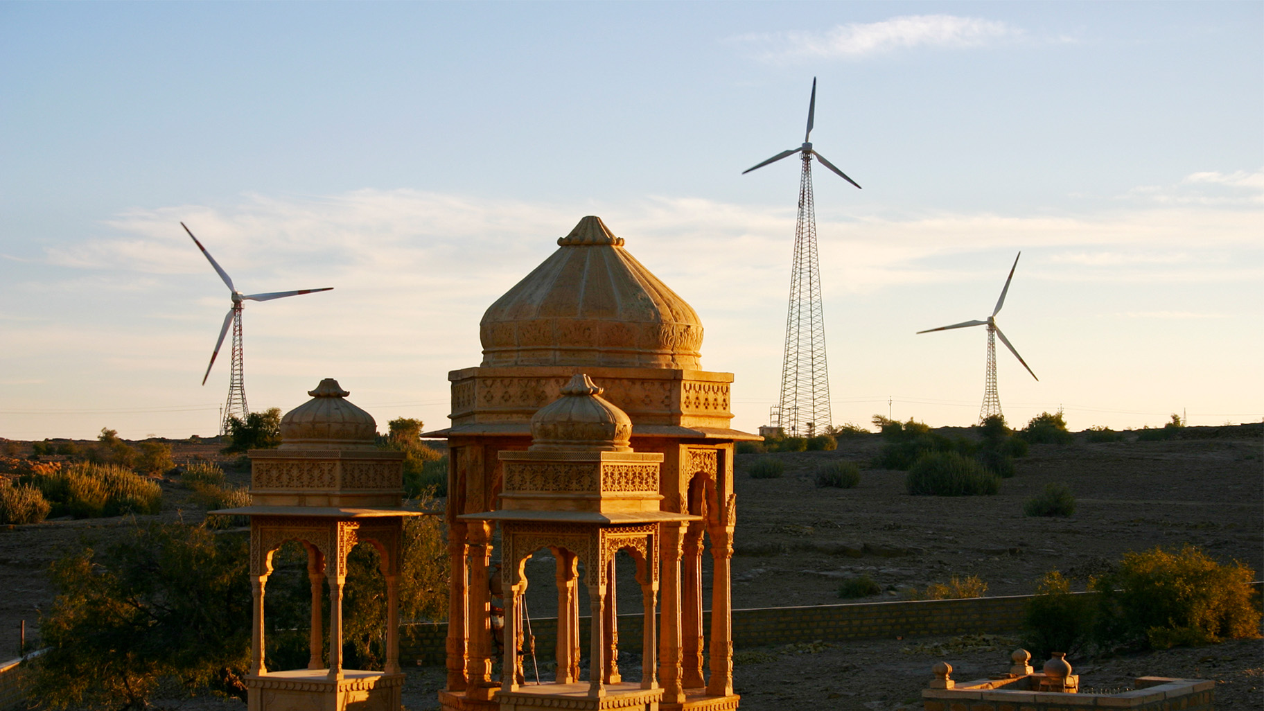 Wind turbines appear behind a structure in India.