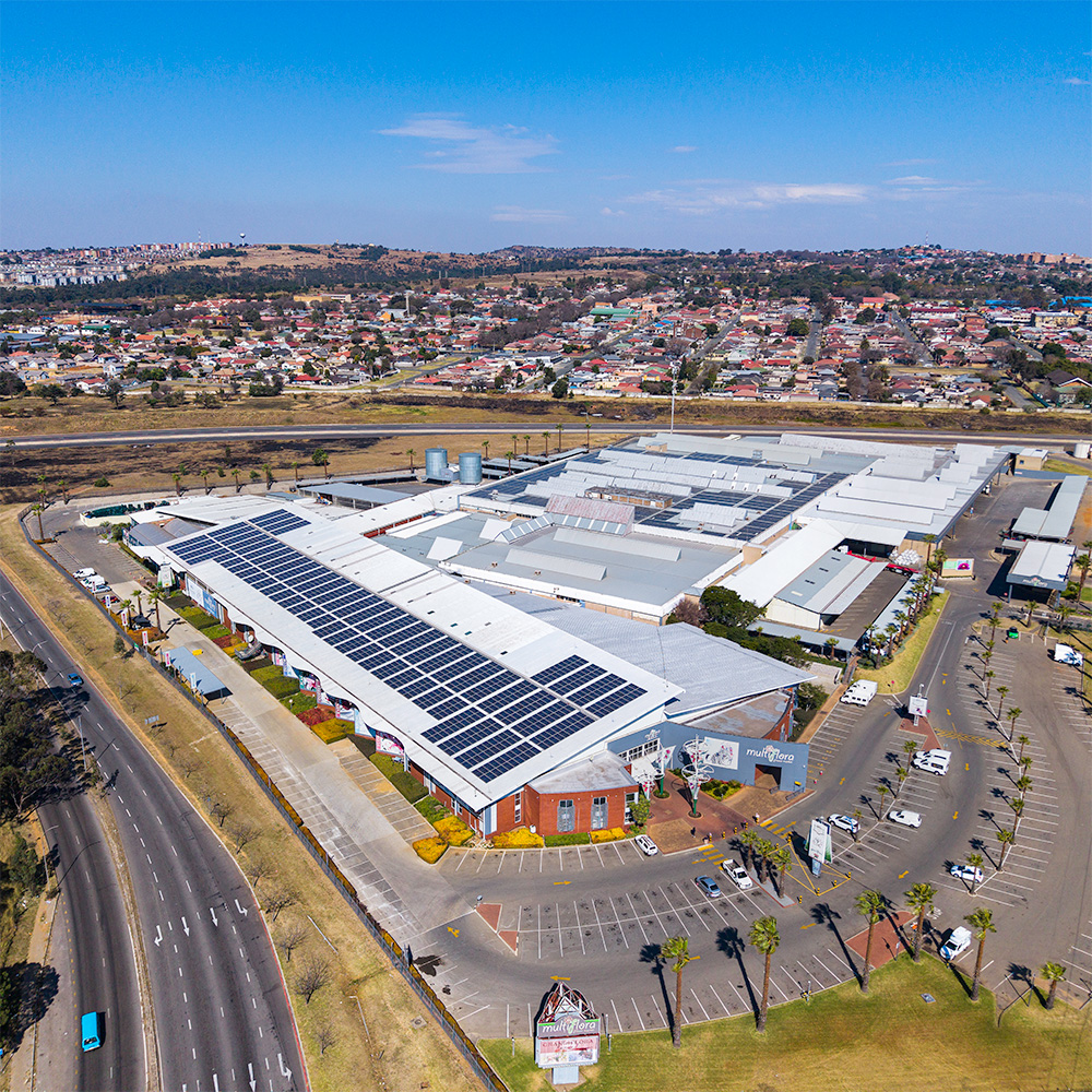 Aerial view of large public building with rooftop solar panels.