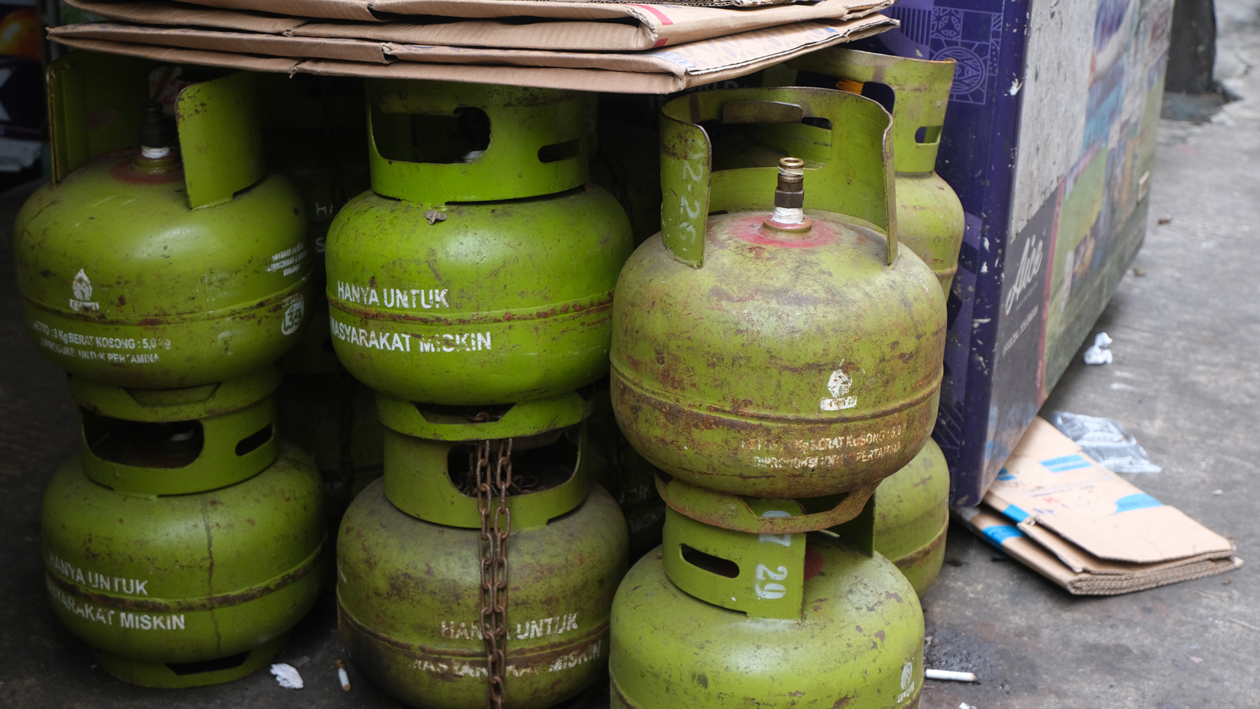 Lime green LPG canisters stacked on top of each other and next to each other.