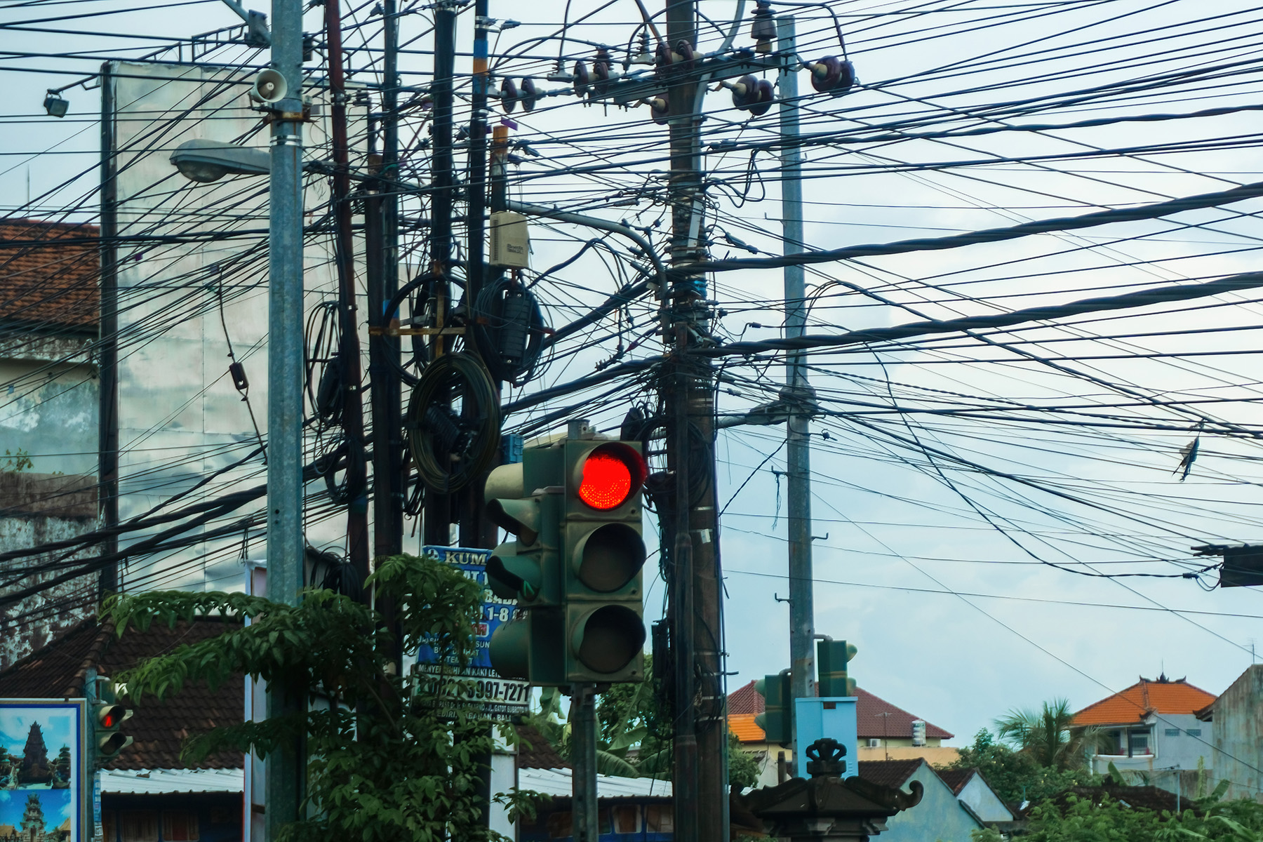 Dense, tangled power lines against a blue sky.