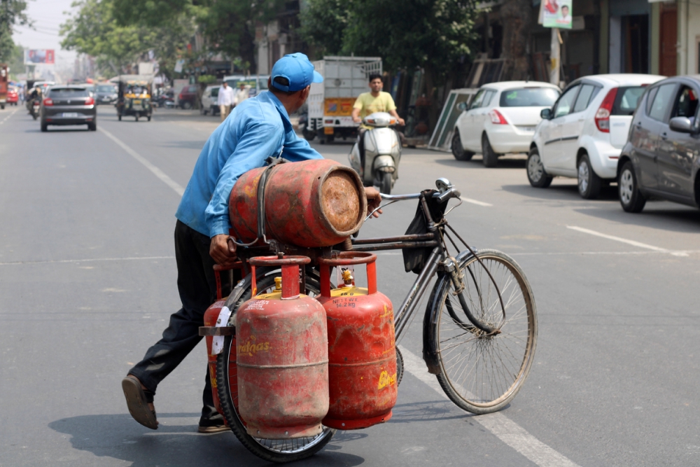 Rohtak, Haryana, India - blue collar worker delivering LPG gas cylinder on cycle.