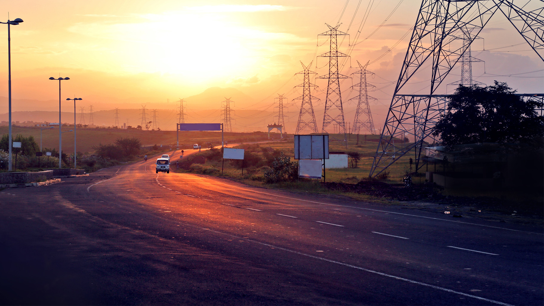 Highway at sunset by powerlines in India