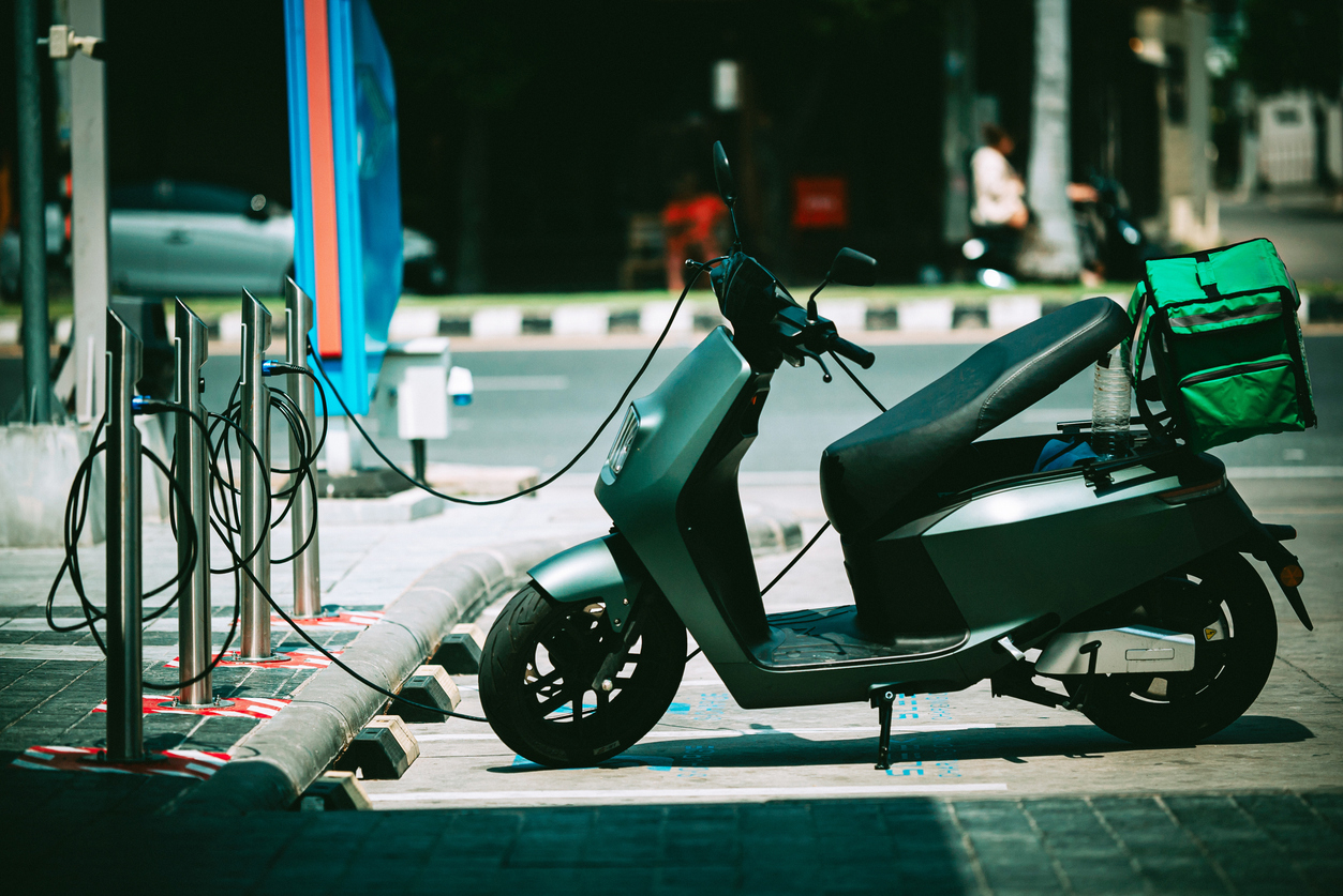 EV scooter being charged in a nighttime setting