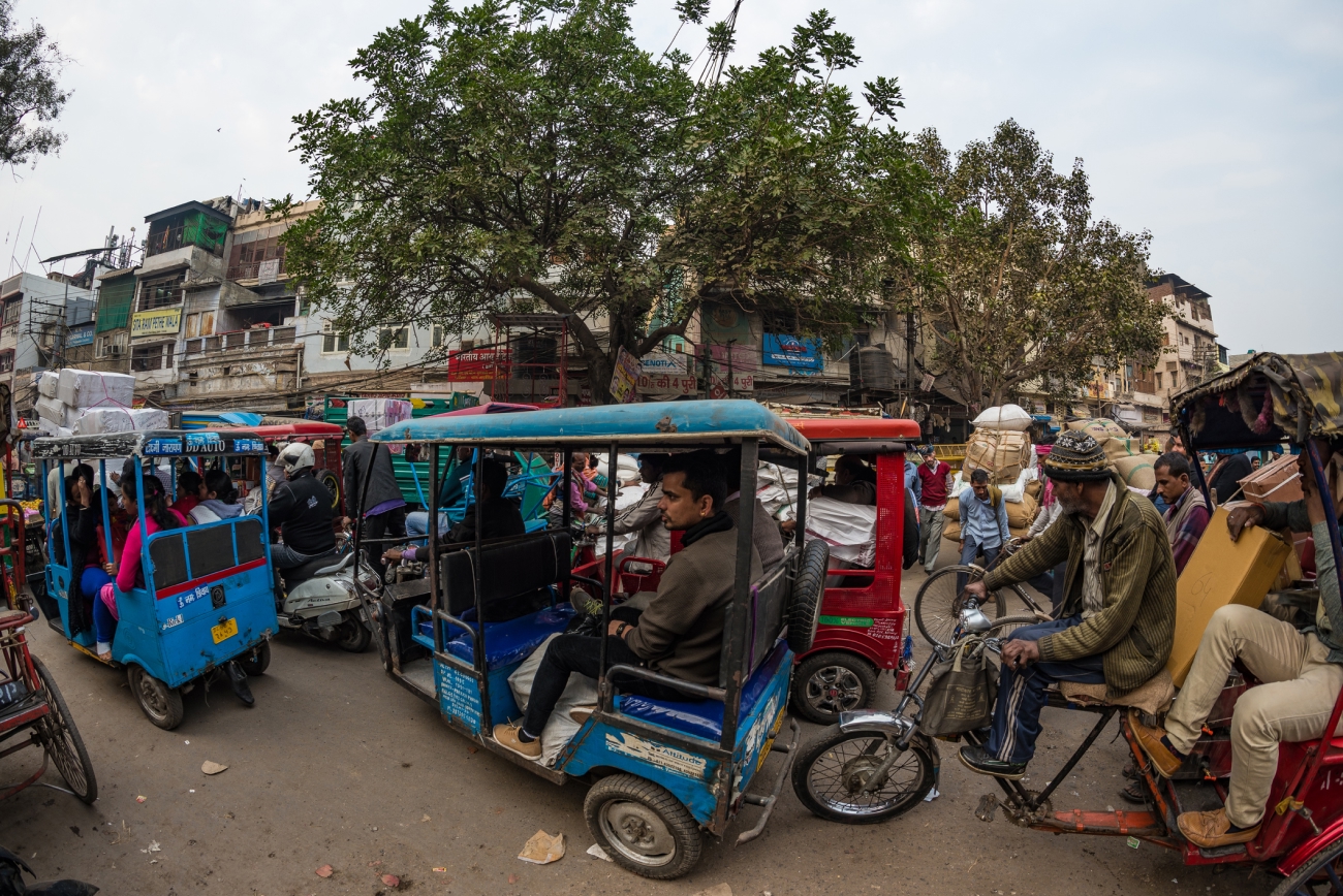 Crowd and traffic on street at Chandni Chowk, Old Delhi, famous travel destination in India. Chaotic city life, working people, fisheye ultra wide view.