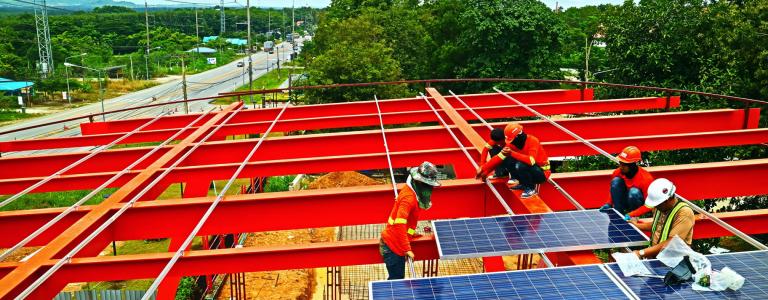 Workers adding solar panels on a construction site