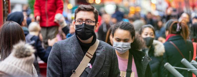 People wear COVID-19 masks on crowded London street