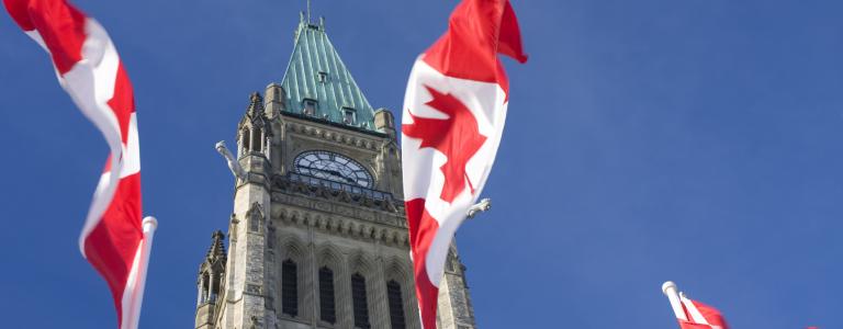 Canadian flags wave outside the parliament building