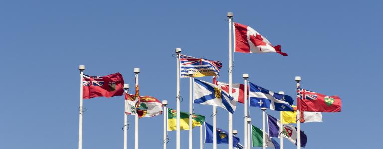 Canada and provincial flags against a blue sky