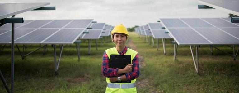A worker standing near solar panels