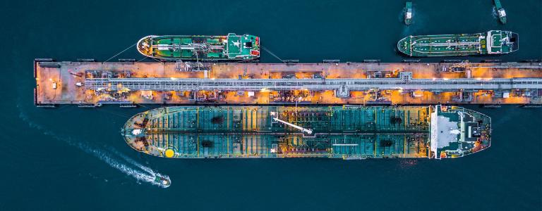 Aerial view of oil tanker ship at the port, Oil terminal is industrial facility for storage of oil and petrochemical products ready for transport to further storage facilities.