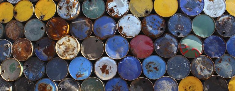 Huge stack of colourful empty oil barrels