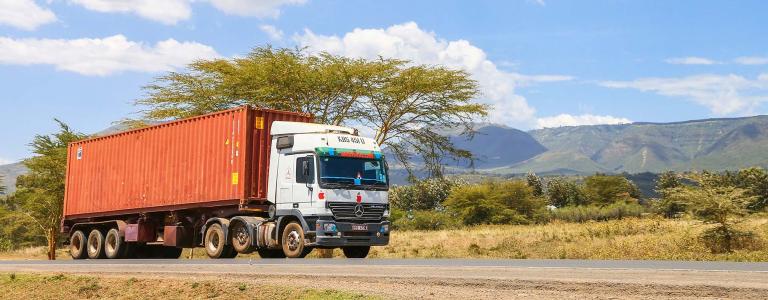 Shipping truck driving on highway and Kenya. 