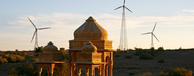 Wind turbines appear behind a structure in India.
