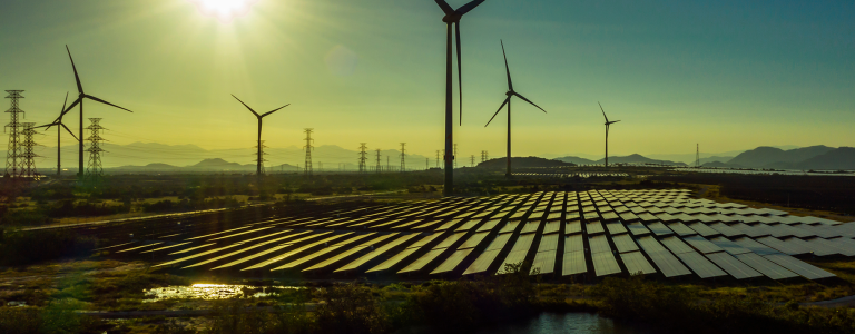 Wind and solar power park at sunset