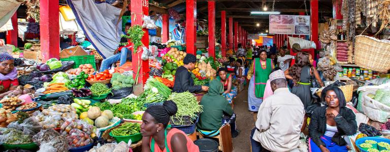 Vendors sell fruit and vegetables at a market in Uganda.