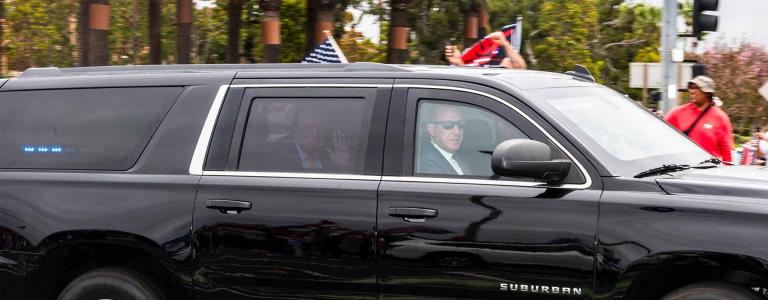 Trump waves from a black SUV