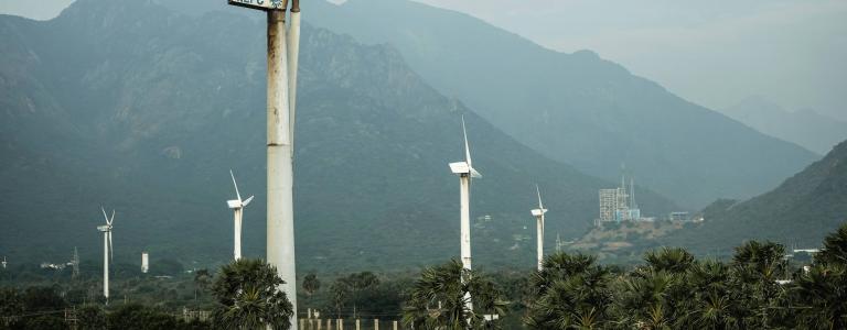 Wind turbine in a landscape with mountains and a gray sky above