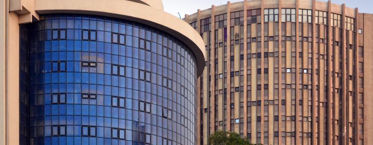 View of a two modern buildings side by side with blue sky on top 