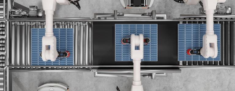 High angle of robotic arms producing solar panels in a warehouse