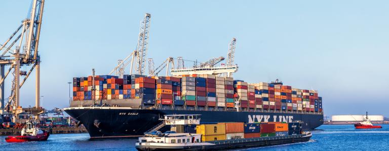 Trade ships filled with cargo passing each other in the sea