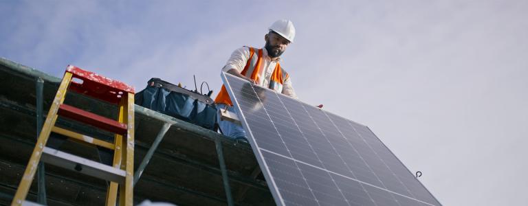 Two men install a solar panel