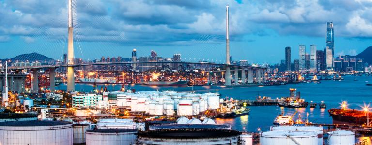 A fossil fuel refinery. There is a city skyline in the background.