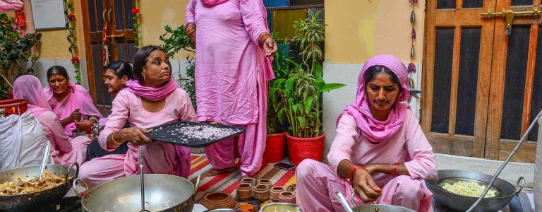 A group of women cook together.
