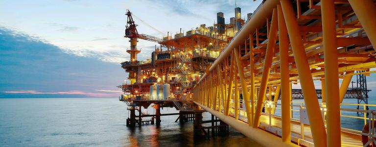 A construction platform for oil and gas production sits in open waters.